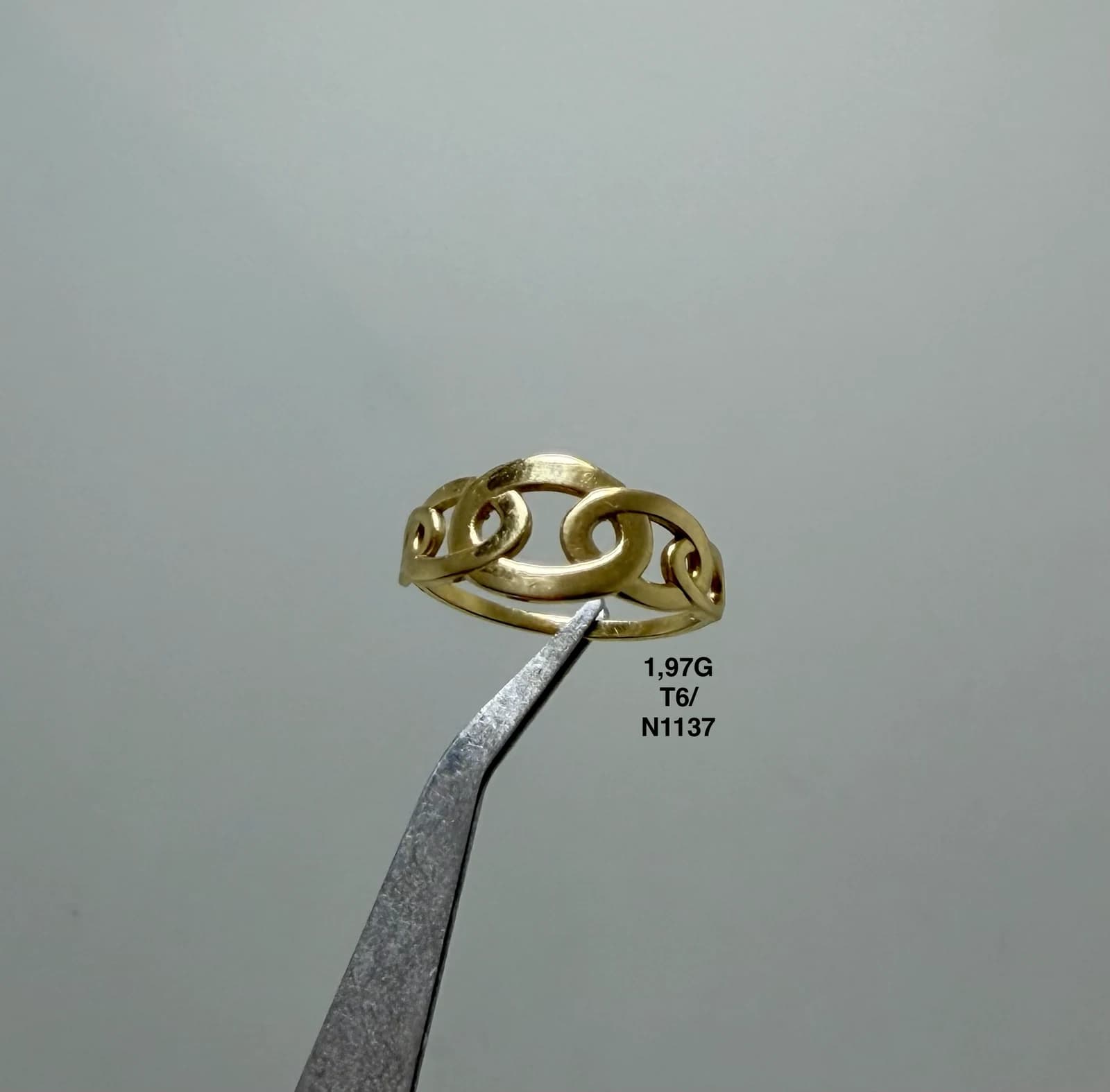 Anillo de eslabones sostenido con pinzas