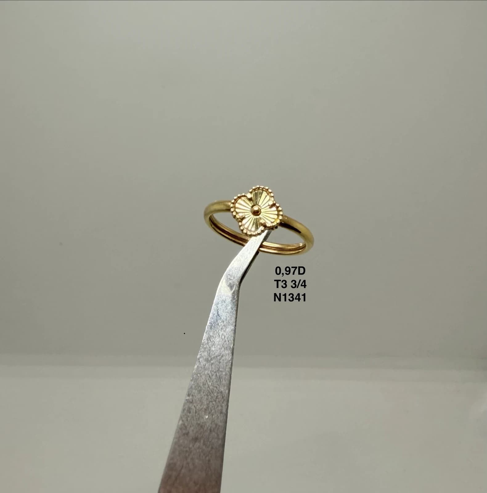 Anillo con motivo floral sostenido con pinzas