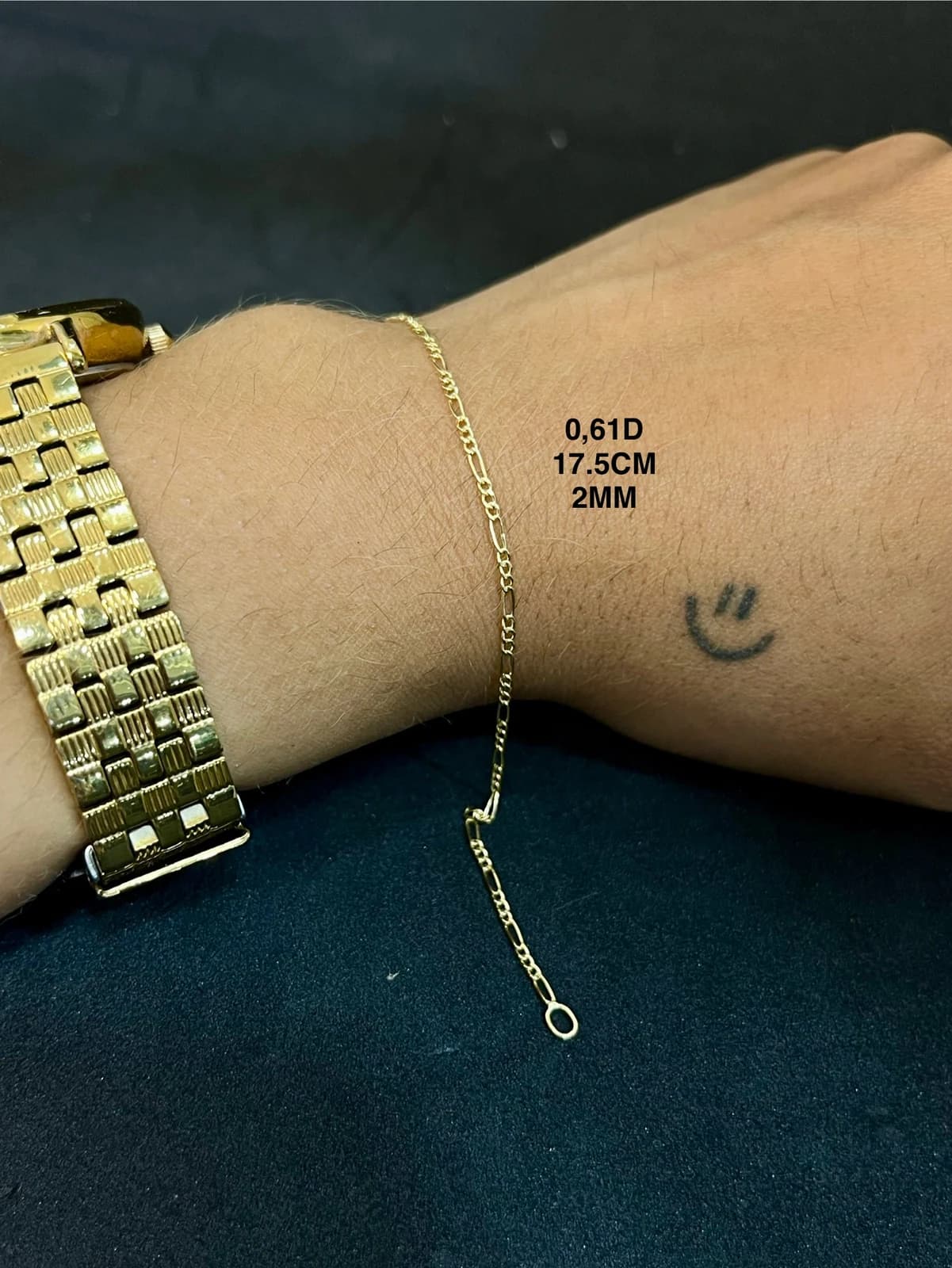 Pulsera delicada sobre una muñeca junto a un reloj