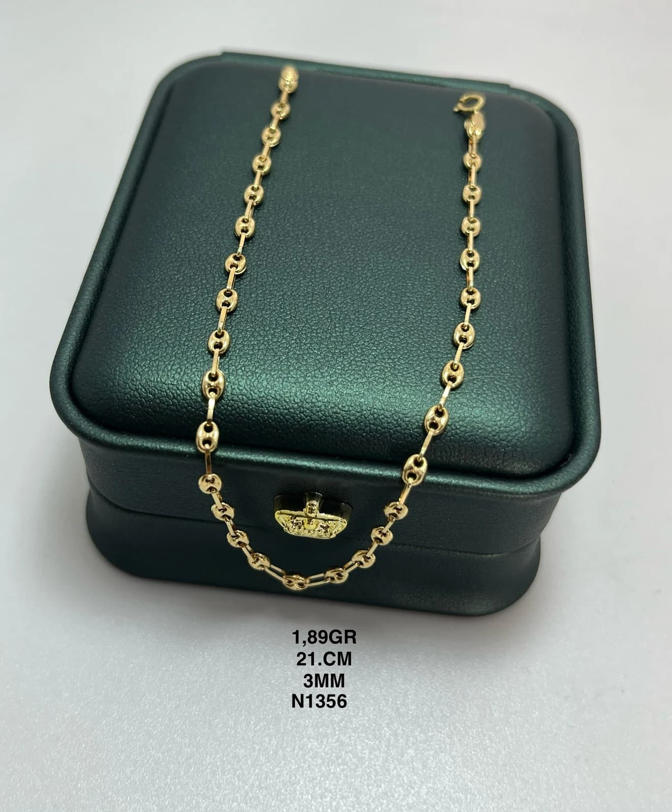 Pulsera de eslabones ovalados sobre un estuche verde